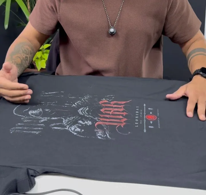 Estampa recém-aplicada em camiseta na bancada